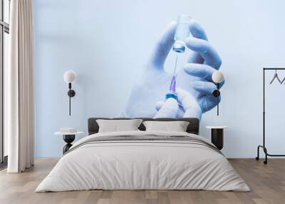 Close up doctor's hand holding medicine bottle and syringe for vaccine to patient on blue tone background.Nurse using syringe are vaccination to patient for influenza protection.Medication concept. Wall mural