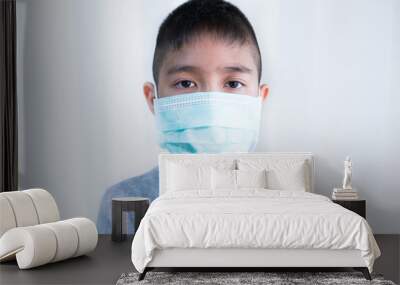 Portrait Asian kid wearing medical mask.A boy wearing mouth mask against air smog pollution. Concept of corona virus quarantine or covid-19.Protection against virus and infection control concept. Wall mural