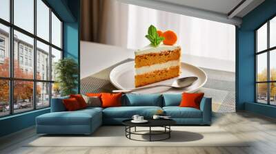 Homemade carrot cake with cream cheese frosting decorated with mint leaves on white plate over white kitchen in the room Wall mural