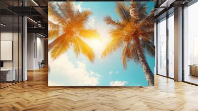 Palm trees under a bright sun in a blue sky. Wall mural