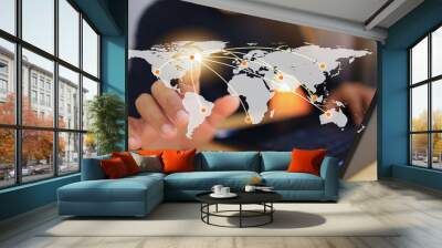 a businessman works with laptops and touch the virtual screen world map to distribute and transport  Wall mural