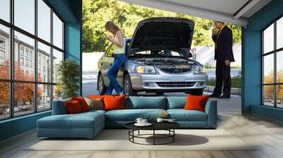 the guy repairs the car, the girl stands nearby Wall mural