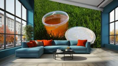 Plastic bucket with freshly collected herbal honey on the mown l Wall mural