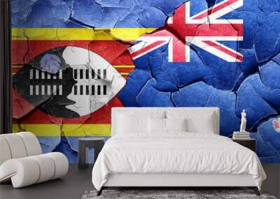 Swaziland flag with Cayman islands flag on a grunge cracked wall Wall mural