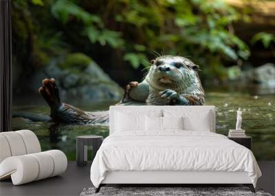 A playful otter floating on its back in a clear mountain stream, holding a stone, surrounded by green foliage Wall mural