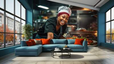 African American female chef having fun while preparing food in the kitchen at restaurant. Wall mural