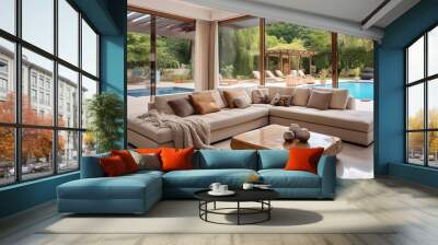 Beige leather corner sofa in room with big windows with view to patio and swimming pool. Interior design of modern living room in luxury villa. Wall mural