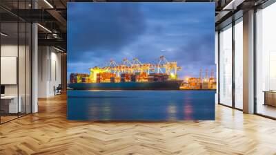 Container Cargo freight ship with working crane bridge in shipyard at dusk for Logistic Import Export background. Containers loading by big crane during twilight, Shipping Trade Port in Thailand Wall mural