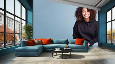 Afro american woman wearing black sweatshirt isolated on pastel Wall mural