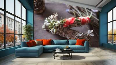 woman doing traditional ritual with herbs tying them with cotton thread accompanied by incense Wall mural