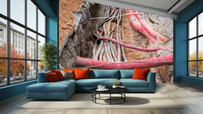 red corrugated pipe are buried underground on the street. underground electric cable infrastructure installation. Construction site with A lot of communication Cables Wall mural