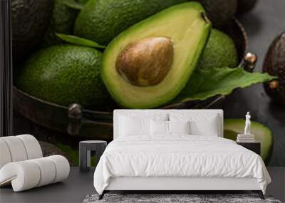 Fresh avocados in a vintage dish on the table. Wall mural