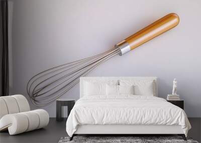 A stainless steel whisk with a wooden handle isolated on a white background. Wall mural