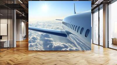 Aerial view from an airplane wing above fluffy clouds with a bright sun illuminating the sky, perfect for travel and aviation themes. Wall mural