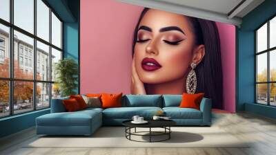 Elegant portrait of a woman showcasing stunning makeup and accessories against a soft pink backdrop. Wall mural