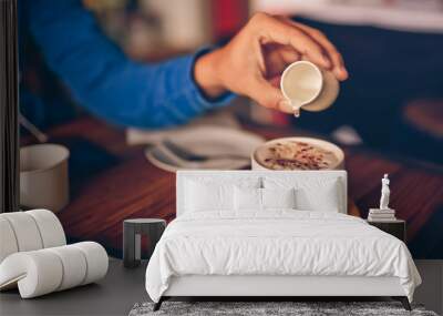 Man hand pouring a syrup onto a hot coffee cup. Wall mural