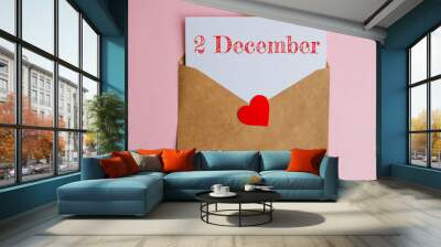 Kraft envelope with a white sheet of paper and a date 2 december, with a red heart. Flat lay on pink background, romance and love concept Wall mural