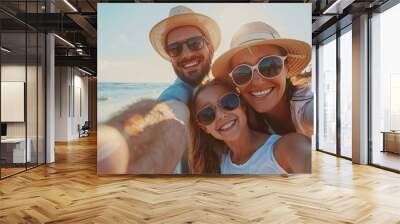 A happy family of four enjoys a sunny beach day, taking a close-up selfie with palm trees in the background and radiant smiles. Wall mural