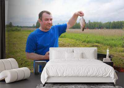 Man puts fish into cauldron Wall mural