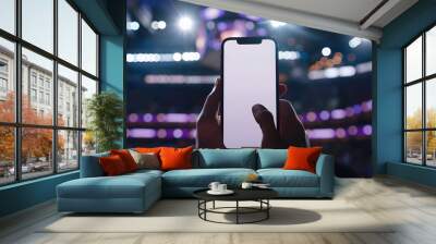 Man fan hands holding isolated smartphone device in basketball crowed stadium game with blank empty white screen, sports betting concept Wall mural