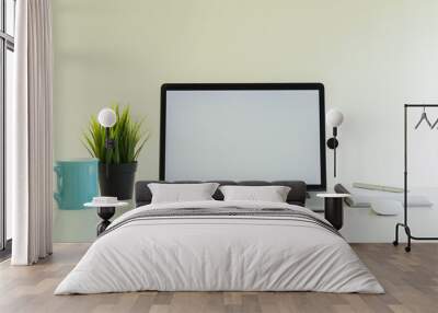 A laptop and a grass coffee mug with a notebook on the desk Wall mural