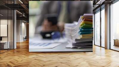 Businessman working in finance with pile of unfinished papers on the desk business paper pile Wall mural