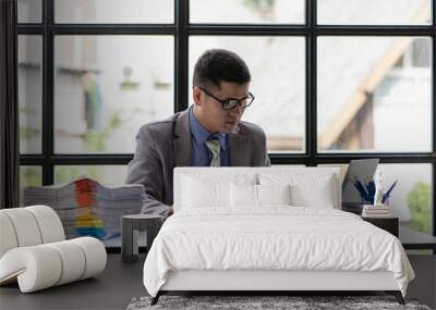 Businessman working with piles of papers on a concept table, calculating, analyzing financial accounts. Wall mural