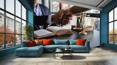 Lawyers shake hands with businessmen to make a deal. legal advisor Various contract consulting services to plan court proceedings with scales and hammers placed beside Wall mural