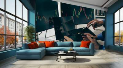 Stock trader looking at stock market chart on screen, analyzing investment strategy, finance working with monitor screen with stock charts and indicators, people working hard to make risk decisions Wall mural