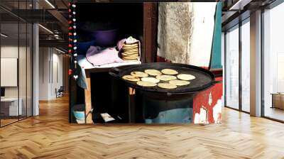 view of female indigenous hand making tortillas on comal, traditional food Wall mural