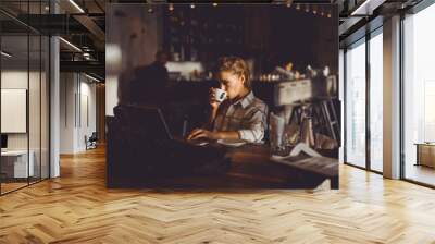 outdoor portrait of a young girl she works as a freelancer in a cafe drinking a delicious hot Cup of coffee from text send mail loads the photo instagram freelancer drinking cappuccino in sunglasses Wall mural