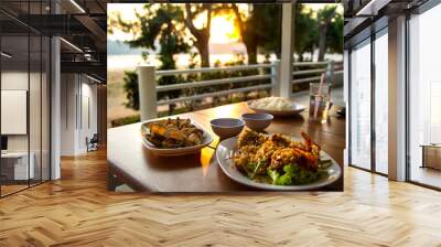 dining table with seafoods with golden light on sunset at seafoo Wall mural