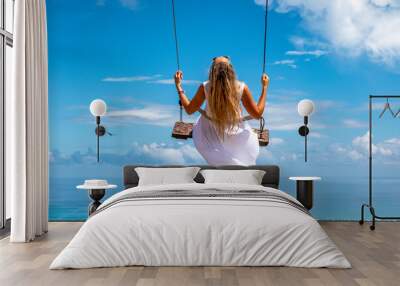 Woman swinging on swings over the green mountains with ocean sea caribbean tropical landscape and horizon line with blue sky. Montana Redonda, Dominican republic. Wall mural