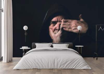 portrait of a man with a hoodie holding a hand in front of his face Wall mural