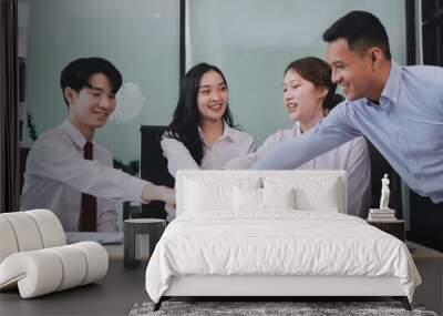 Group of business workers standing with hands together at the office Wall mural