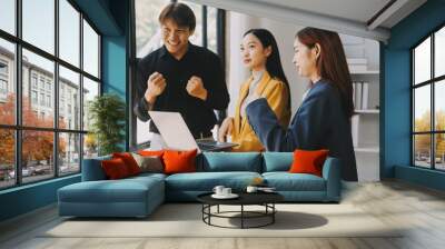 Group of Young Asian business team creative businesspeople coworker in office Happy to be successful partnership teamwork celebrating achievement and success concept. Wall mural