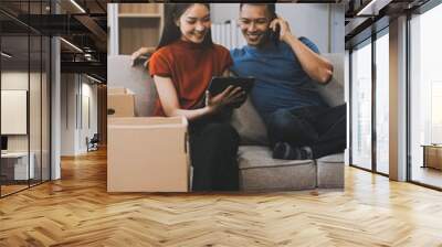 Happy excited, smiling asian young couple love using tablet pc, great deal or business success, received or getting cash back, tax refund, good news by mail while sitting on floor at home. Wall mural