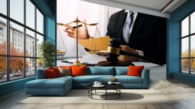 Justice and law concept.Male judge in a courtroom with the gavel, working with, computer and docking keyboard, eyeglasses, on table in morning light Wall mural