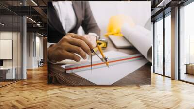 Two colleagues discussing data working and tablet, laptop with on on architectural project at construction site at desk in office Wall mural