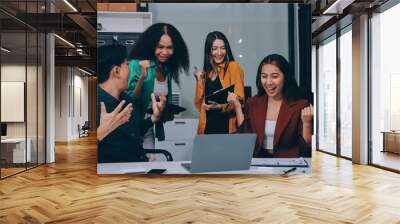 Young corporate employees sitting in office looking at laptop screen reading good news excited happy team diverse people celebrating victory win command success excellent result professional teamwork Wall mural