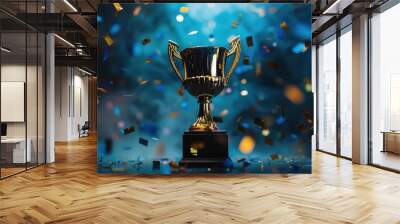 A golden trophy with confetti falling around it against a dark blue background. The trophy is a symbol of success, achievement, and victory. Wall mural