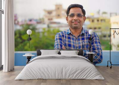 Cheerful Indian man wearing glasses, a successful businessman smiling. Wall mural