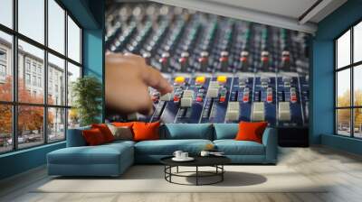 Men's hands are controlling the console of a large hi-fi system. Sound equipment. Control panel of a digital studio close-up mixer. Wall mural