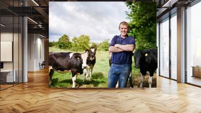 Portrait, agriculture and cows with a man on a dairy farm outdoor in summer for natural sustainability. Confident, milk or meat farming and a young male farmer standing on an open field or meadow Wall mural