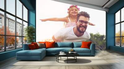 Flying high with my daddy. a happy father giving his daughter a piggyback ride outside in nature. Wall mural