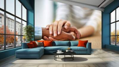 Dont worry Im here for you. Cropped shot of two unrecognizable people holding hands while being seated at a table inside during the day. Wall mural