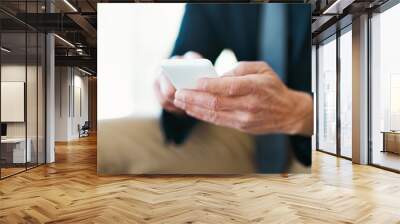 Hes easy to reach. High angle shot of an unrecognizable businessman sending a text message. Wall mural