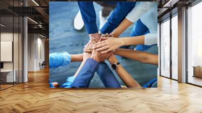 Lets awaken the team spirit. High angle shot of a group unrecognizable businesspeople joining their hands together in unity. Wall mural