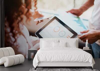 This is how are progression should look like. Shot of two unrecognizable peoples hands working on a tablet and looking at the businesss charts in the office. Wall mural