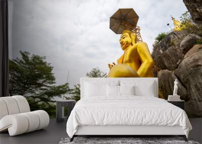 The big gold Buddha statue at Tham Champathong monastery, Ratchaburi, Thailand Wall mural